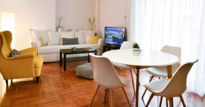 a living room with a couch and a table and chairs at DARSISS 1 - Museum Apartment in Athens