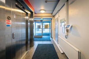 a hallway in an office building with a door and a hallway sidx sidx at Omena Hotel Jyväskylä in Jyväskylä +11 photos