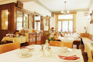 een restaurant met tafels en stoelen en een eetkamer bij Landhaus Michels garni in Kaarst