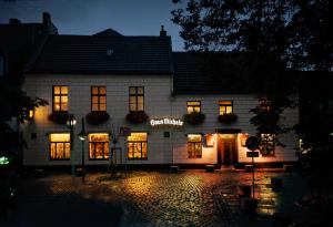 a building with lights on in the night at Landhaus Michels garni in Kaarst