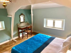 a bedroom with a bed and a mirror and a table at Le Chevalier Noir in Cordes-sur-Ciel