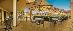 an outdoor patio with tables and chairs and umbrellas at Hotel Buchlovice in Buchlovice