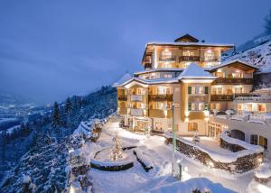 un hotel su una montagna innevata di notte di Hotel AlpenSchlössl a Sankt Johann im Pongau