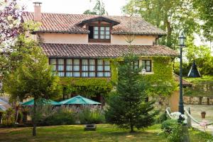 Una casa con hiedra a un lado. en La Lobera en Las Rozas de Valdearroyo