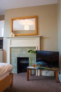 a living room with a television and a fireplace at Amherst Brighton in Brighton & Hove