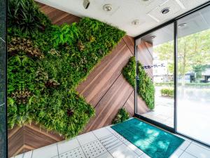 un jardín vertical en la pared de un edificio en Super Hotel JR Shin-Osaka Higashiguchi, en Osaka