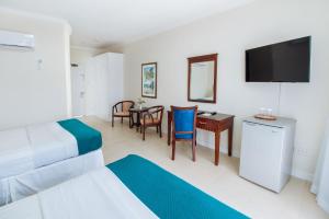 a bedroom with a bed and a desk and a television at Bay Gardens Marina Haven in Gros Islet