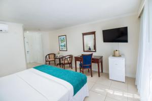 a bedroom with a bed and a table and a television at Bay Gardens Marina Haven in Gros Islet