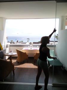 a woman is standing in front of a window at Azahara Beach 416 in Los Cristianos