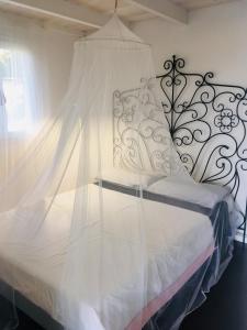 1 dormitorio con 1 cama blanca con dosel en Playa Di Valverde, en Galliate