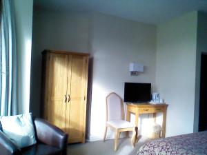 1 dormitorio con 1 cama y escritorio con ordenador en Mountbatten Hotel en Plymouth