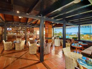 restauracja ze stołami i krzesłami oraz widokiem na ocean w obiekcie Hotel Baia Cristal Beach & Spa Resort w mieście Carvoeiro
