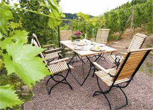 uma mesa de madeira e cadeiras num jardim em Weingut Mariaberg em Meissen