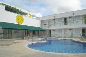 a hotel with a swimming pool in front of a building at Hotel Calarca Club in Montería