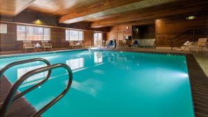 a large swimming pool in a hotel with tables and chairs at Best Western Plus Meridian in Meridian