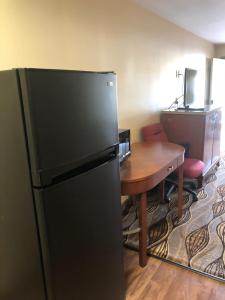 cocina con nevera y mesa de madera en Budget Inn Williamsport, en Williamsport