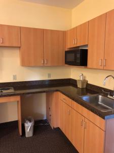 a kitchen with a sink and a microwave at Budget Inn Williamsport in Williamsport +22 photos