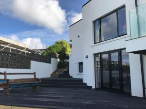 a white building with a bench next to it at Fistral Hideaway in Newquay