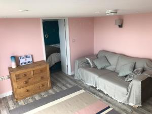 a living room with a couch and a bedroom at Fistral Hideaway in Newquay