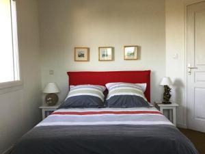een bed met een rood hoofdeinde in een slaapkamer bij Chambre d'hôtes - La Maison de Jane in Jullouville-les-Pins
