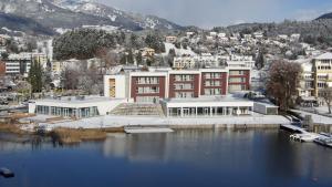 un grande edificio accanto a un corpo idrico di Hotel Royal X a Seeboden