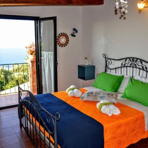 a bedroom with a large bed with green and blue sheets at B&B Le Anthos in Marina di Camerota