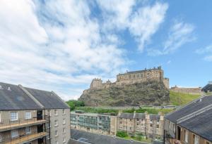 un château au sommet d'une colline avec des bâtiments dans l'établissement ALTIDO Warm and Welcoming flat near Edinburgh Castle, à Édimbourg