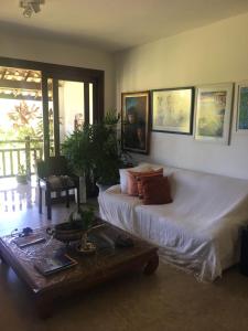 a bedroom with a large bed and a table at Condomínio Reserva Imbassai in Imbassai