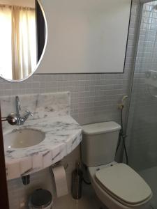 a bathroom with a sink and a toilet and a mirror at Condomínio Reserva Imbassai in Imbassai +11 photos