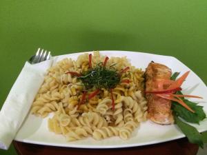 a white plate of pasta with meat and vegetables at Bussarin Mansion in Ko Yao Yai