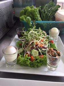 une assiette avec une salade et deux verres d'eau dans l'établissement Bussarin Mansion, à Ko Yao Yai