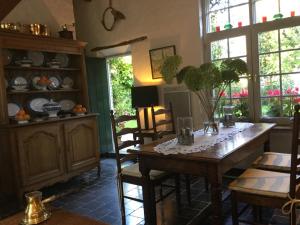 a dining room with a wooden table and chairs at B&B Auberge De Klasse in Veurne