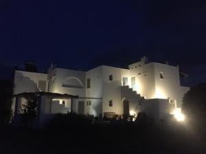 un edificio blanco por la noche con sus luces encendidas en Helios Beach Studios, en Plaka