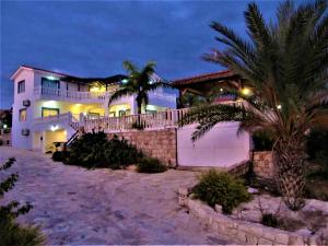 a house on the beach at night at Villa Dioni in Coral Bay