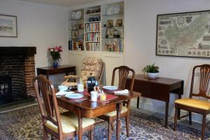 uma sala de jantar com uma mesa e cadeiras e uma lareira em St Mary’s Bed & Breakfast em Bury Saint Edmunds