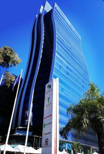 un edificio alto con un cartel delante en Paseo La Galería Hotel & Suites, en Asunción