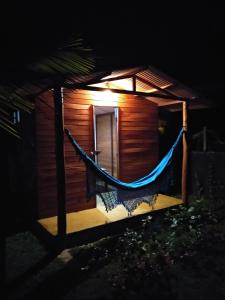 a hammock in front of a house at night at Family Guest House in Ilha de Boipeba