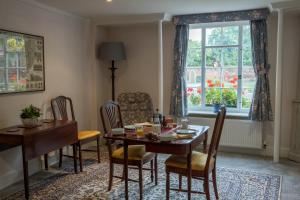 uma sala de jantar com uma mesa e cadeiras e uma janela em St Mary’s Bed & Breakfast em Bury Saint Edmunds