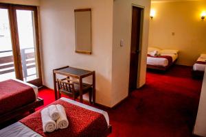 Habitación de hotel con 2 camas y espejo en Ayelen Hotel de Montana en Los Penitentes