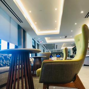 a lobby with chairs and tables in a building at Wyndham Garden Ft Lauderdale Airport & Cruise Port in Dania Beach