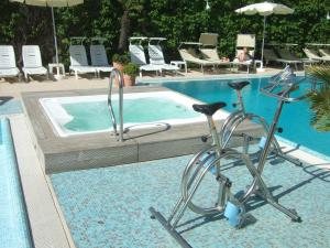 a swimming pool with a bike parked next to a swimming pool at Hotel Derby Exclusive in Milano Marittima