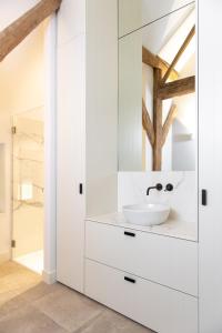 a white bathroom with a sink and a mirror at Winning De Zwaen in Hasselt