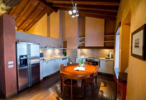 uma cozinha com uma mesa de madeira e uma cozinha com electrodomésticos de aço inoxidável em Locanda Mimmo em Bérgamo