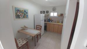 uma cozinha com uma mesa e um frigorífico branco em Eden's Sweet Place em Eilat