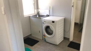 een wasmachine in een badkamer met een wastafel bij Maddington House Unit C in Perth