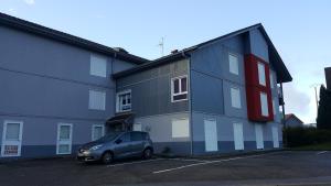 a car parked in a parking lot next to a building at résidence vallée des lacs in Le Tholy
