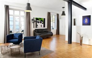 ein Wohnzimmer mit blauen Stühlen und einem Sofa in der Unterkunft Hotel Villa8 in Villingen-Schwenningen