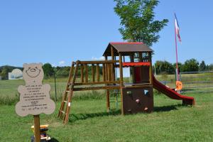 un pequeño parque infantil con un tobogán y un cartel en LES EYCHECADOUS, en Artigat