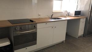 una cucina con piano di lavoro, lavandino e piano cottura di Maddington House Unit A a Perth