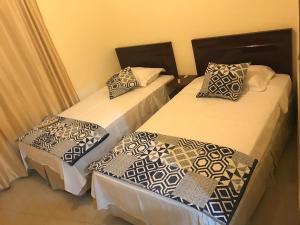two twin beds in a room withskirts at Garzota Suites Airport Balcony in Guayaquil
